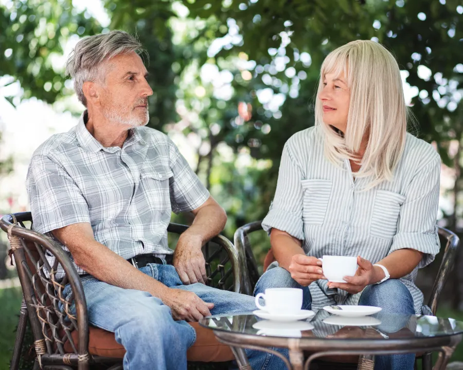 Medium shot couple drinking coffee outside